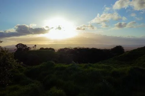 Sun setting into the horizon. The view is from high ground green mountain Stock-Fotos