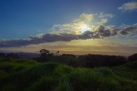 Sun setting into the horizon. The view is from high ground green mountain Stock-Fotos