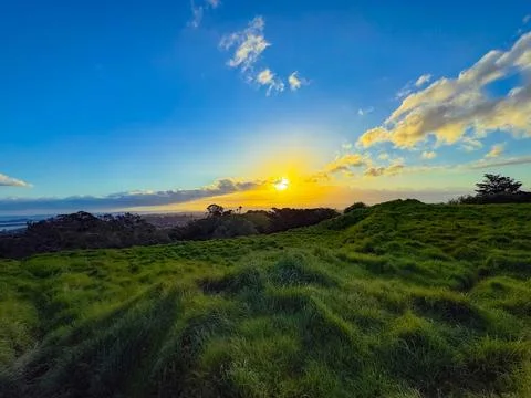 Sun setting into the horizon. The view is from high ground green mountain Stock-Fotos