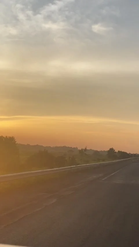 THE SUN SETTING IN THE MIDDLE OF THE HIGHWAY Stock Footage 210184847