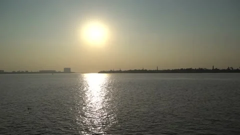 The sun is setting on the other side of the river where civilization has develop Video stock 222497469