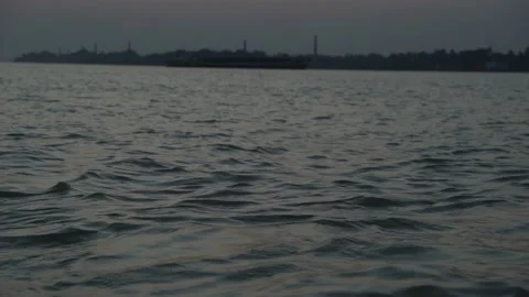 The sun is setting on the other side of the river where civilization has develop Video stock 223823482