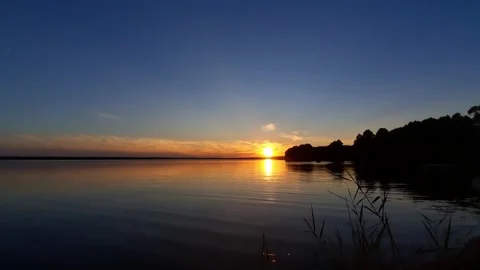 The sun is setting over a body of water, view from the lake,  summer night Stock Footage 280892242