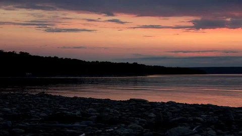 The Sun Setting Over a Calm Lake Stockbeeldmateriaal 77698502
