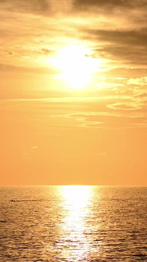 Sun setting over calm sea with golden reflection on water Видео 345080000