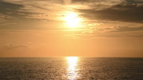 Sun setting over calm sea with golden reflection on water Видео 345080058
