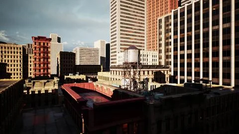 The sun setting over a city skyline, showing the tops of tall buildings Stock Illustration