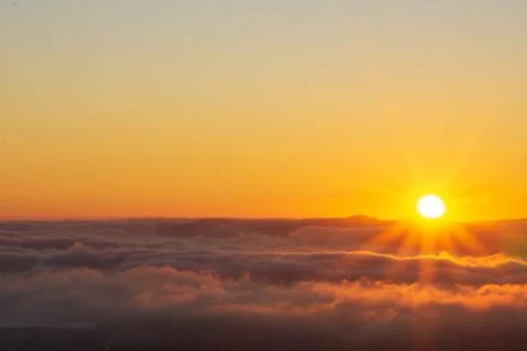 Sun setting over clouds Stock Photos