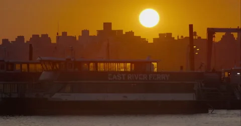 Sun setting over East River Ferry boats docked in marina Stock Footage 67308033