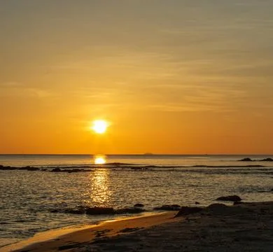 Sun Setting Over an Empty Beach Stock Photos