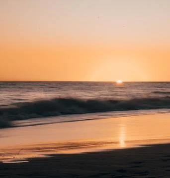 Sun Setting Over an Empty Beach Stock Photos