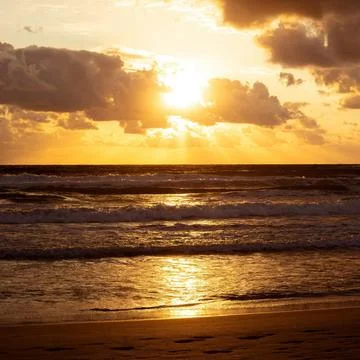 Sun Setting Over an Empty Beach Stock Photos