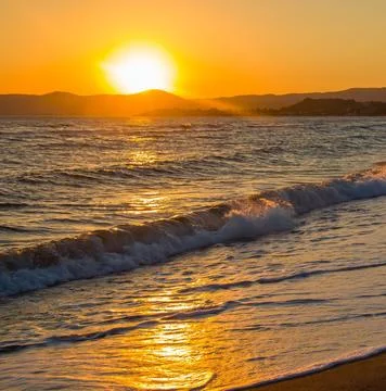Sun Setting Over an Empty Beach Stock Photos