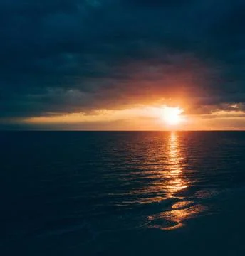 Sun Setting Over an Empty Beach Stock Photos