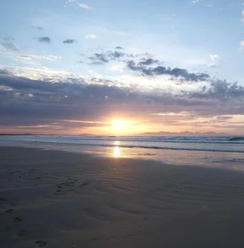 Sun Setting Over an Empty Beach Stock Photos