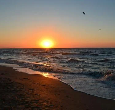Sun Setting Over an Empty Beach Stock Photos