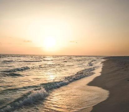 Sun Setting Over an Empty Beach Stock Photos