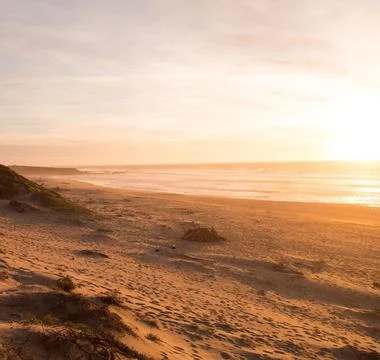 Sun Setting Over an Empty Beach Stock Photos