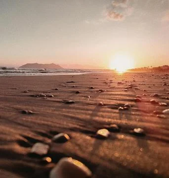 Sun Setting Over an Empty Beach Stock Photos