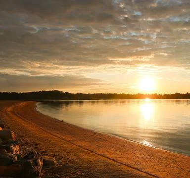 Sun Setting Over an Empty Beach Stock Photos