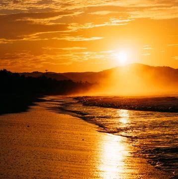 Sun Setting Over an Empty Beach Stock Photos