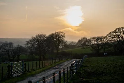 The sun setting over a farm Stock Photos
