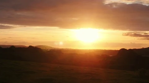 Sun setting over fields creating beautiful red sky Stock Footage 73559297