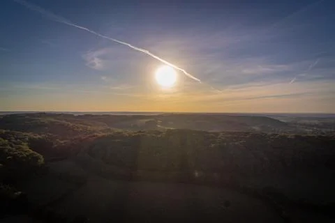 Sun setting over forrest hills in the Eifel region in Germany Stock Photos