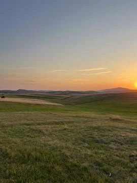 Sun Setting Over Hills and Field, Dramatic Orange Sky Stock Photos