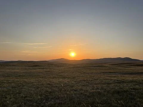 Sun Setting Over Hills and Field, Dramatic Orange Sky Stock-Fotos