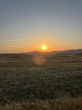 Sun Setting Over Hills and Field, Dramatic Orange Sky Fotos Stock