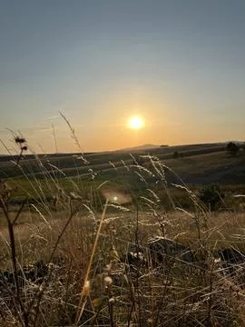 Sun Setting Over Hills and Field, Dramatic Orange Sky Stock Photos