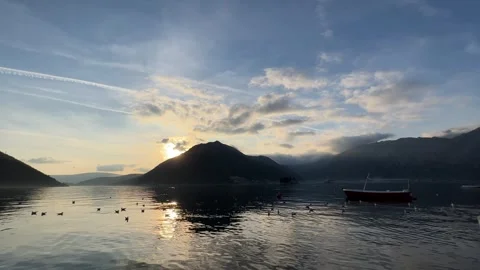 The sun is setting over a lake with mountains in the background Stock Footage 275345645