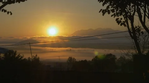 Sun setting over a mountain lake with clouds and powerlines 스톡 동영상 89213564