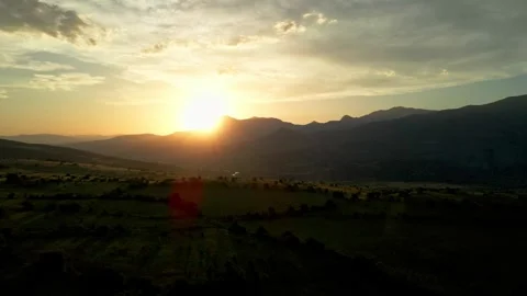 The sun is setting over a mountain range, casting a warm glow over the landscape Stock Footage 327924027