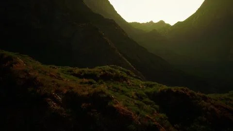 The sun is setting over a mountain range Illustrazione stock
