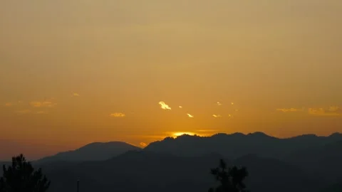 The sun is setting over the mountains, casting a warm glow over the landscape Stock Footage 313716835