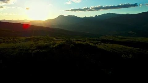 The sun is setting over the mountains, casting a warm glow over the landscape Stock Footage 327923899