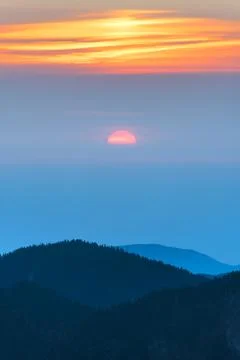 Sun setting over mountains Stock Photos