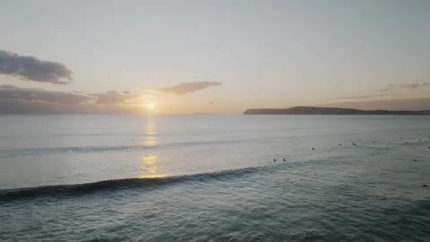 The sun is setting over the ocean, casting a warm glow on the water Stock Footage 297078180