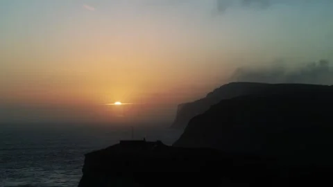 The sun is setting over the ocean, casting a warm glow over the water Stock Footage 303710020