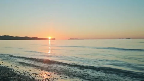 The sun is setting over the ocean, casting a warm glow on the water. Time lapse Video stock 318315094