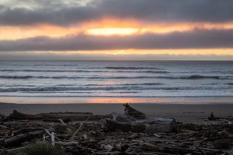 The sun is setting over the ocean, casting a warm glow over the water Stock Photos
