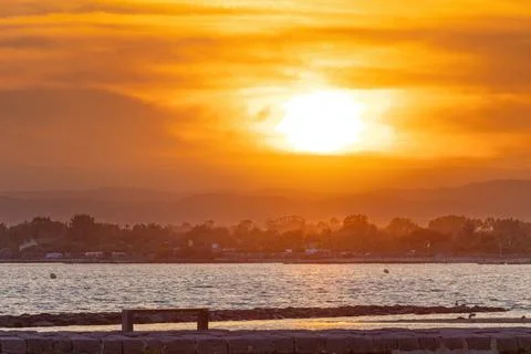 The sun is setting over the ocean, casting a warm glow over the water Stock Photos