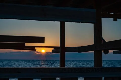 The sun is setting over the ocean, casting a warm glow on the water Foto stock