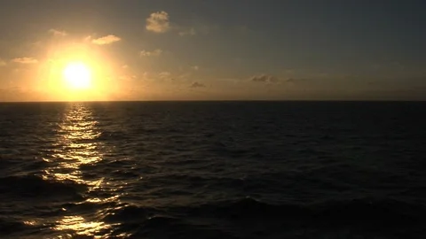 Sun setting over ocean from moving ship (sun on left) Video stock 90499811