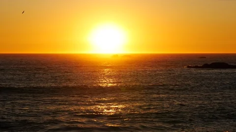 Sun setting over the ocean with orange light reflected on the waves Stock Footage 108947750