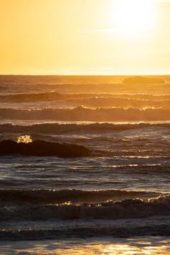 The sun setting over the rough seas of the Pacific Ocean Photos