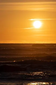The sun setting over the rough seas of the Pacific Ocean Stockfoto's