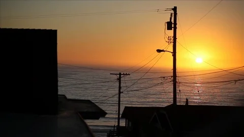 Sun setting over sea and house exteriors. Video stock 88342831